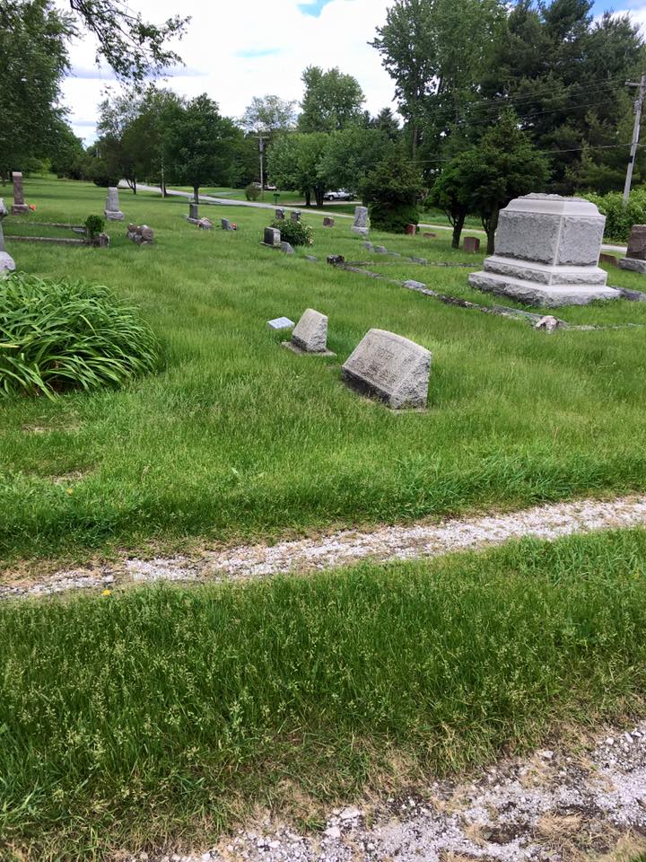 Lush green cemetery grounds with monuments and manicured lawns at Woodlands Cemetery
